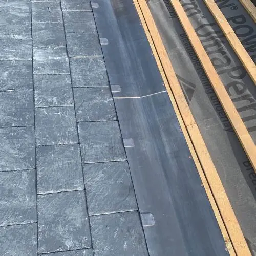 Slate roof valley with lead flashing and timber battens