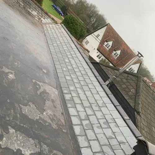 Slate roof with a lead-lined valley being repaired