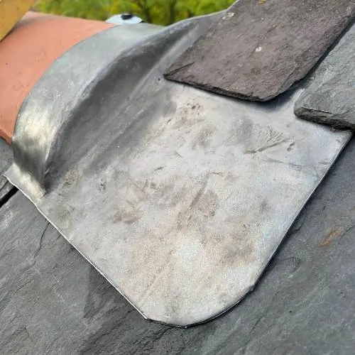 Rolled lead flashing detail around a slate roof corner