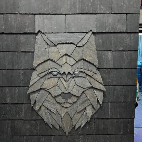 Decorative lynx head made from slate set into a roof