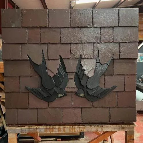 Decorative slate swallows set into a clay tile feature panel